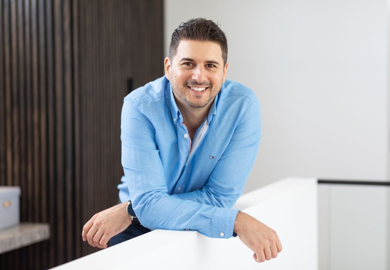 a photo of Christian Hammerle in a blue shirt leaning on a railing